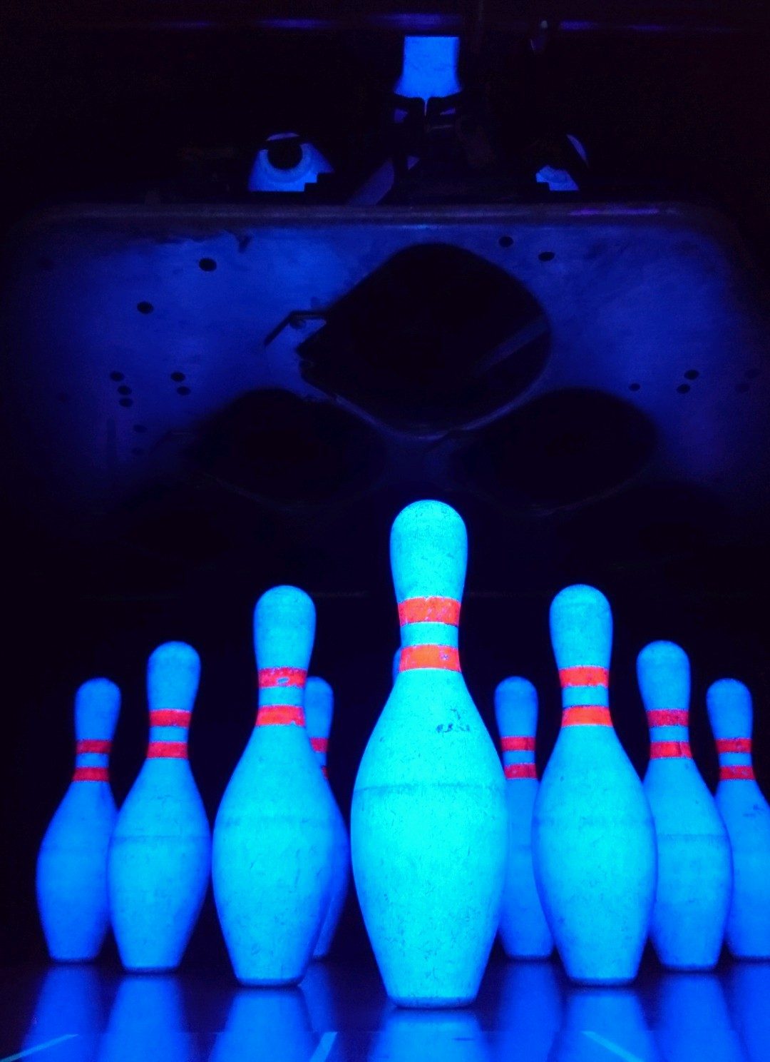 Pinos de bowling iluminados a azul em luz negra